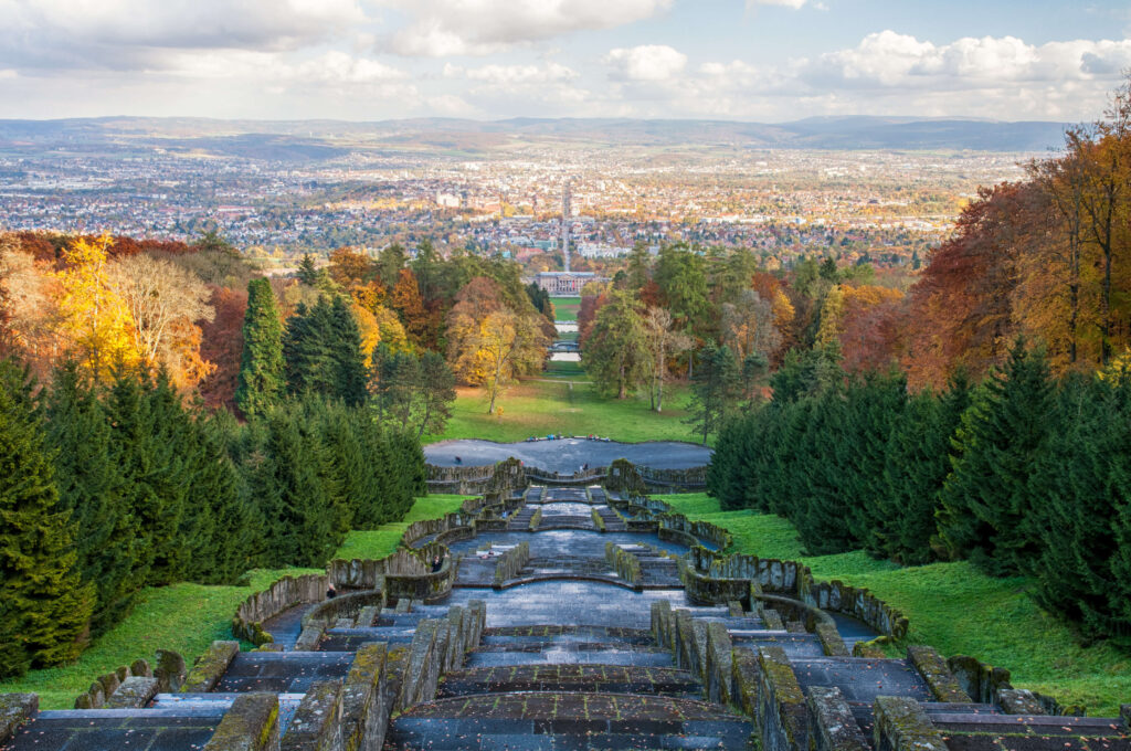 Blick vom Berg runter über Kassel mit Treppen und vielen Bäumen